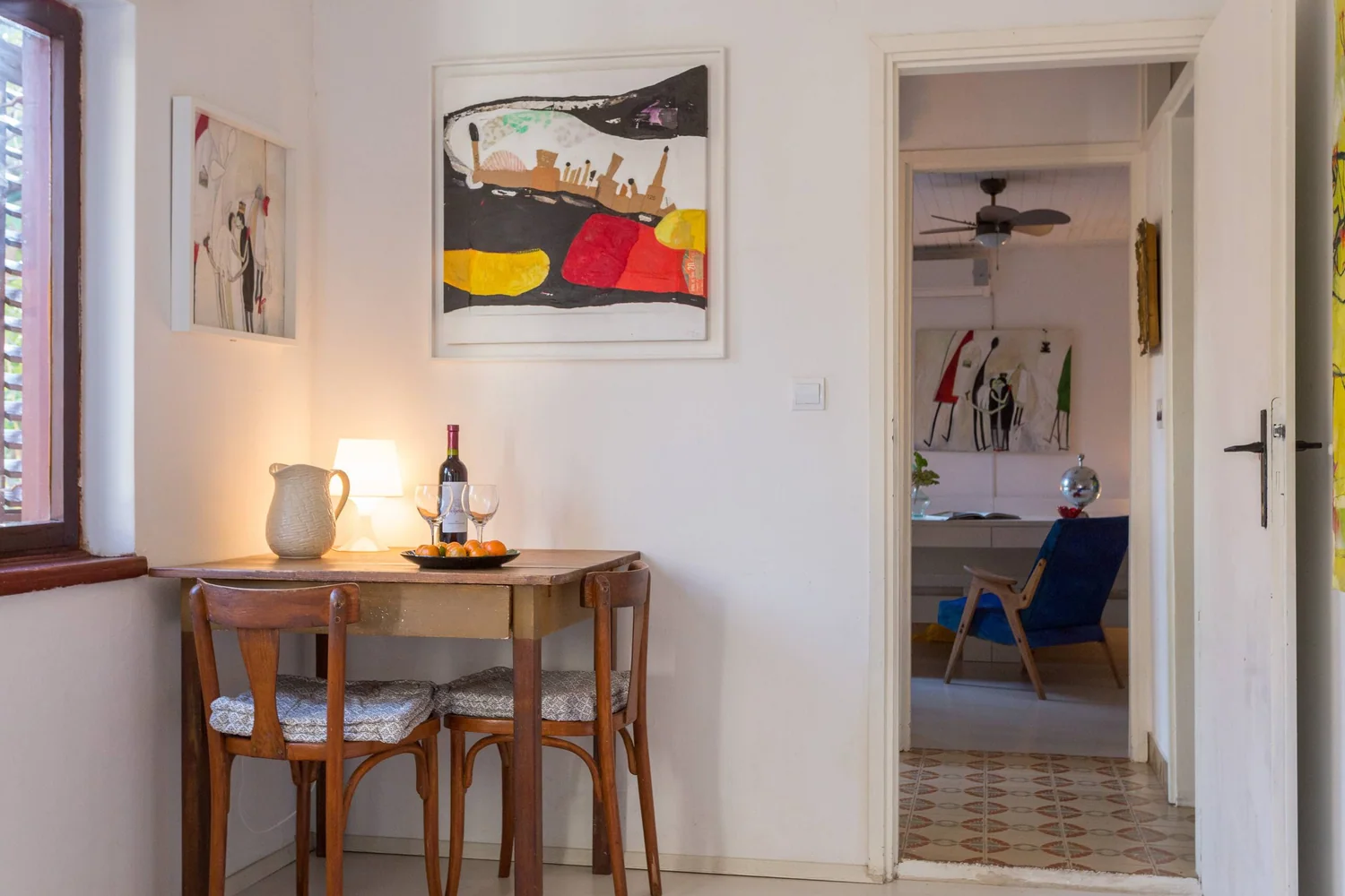 Original paintings installed in a domestic dining room and adjoining room.