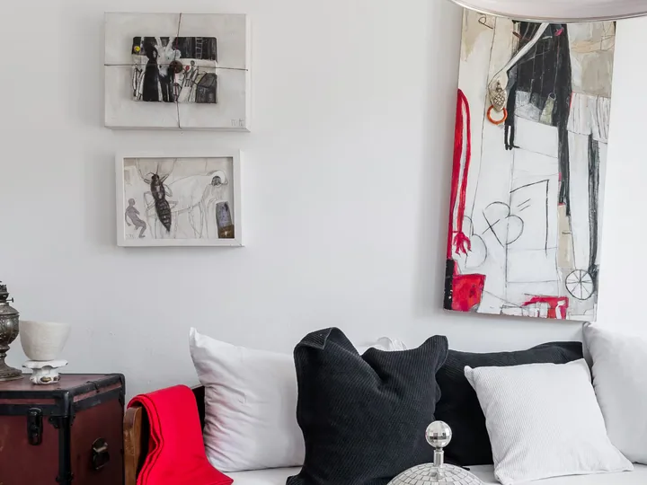 Framed printed works arranged above a sofa.